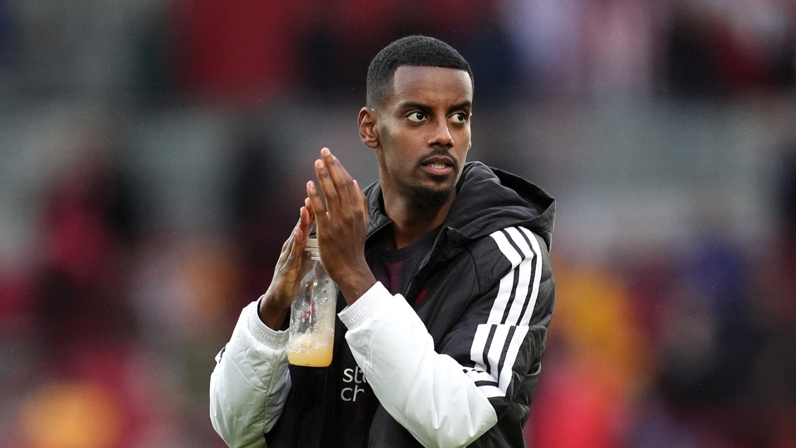 Alexander Isak v bundě Liverpoolu tleská fanouškům po zápase na stadionu Brentfordu