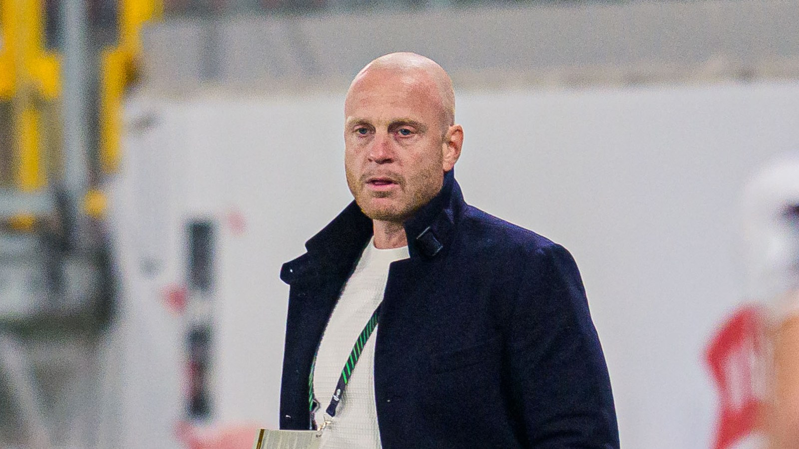 Trenér Andreas Brännström v tmavém kabátě sleduje u lavičky Mjällby zápas Konferenční ligy